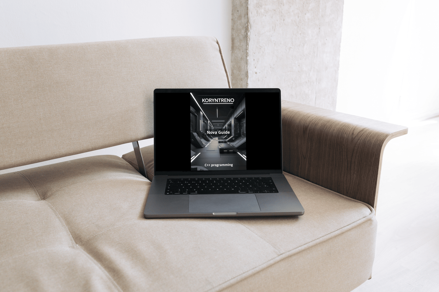Laptop on a beige sofa with a C++ course.