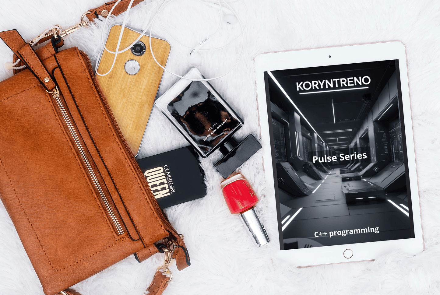 Brown leather wallet, phone, perfume bottle, and tablet with Koryntreno C++ course on a white surface.