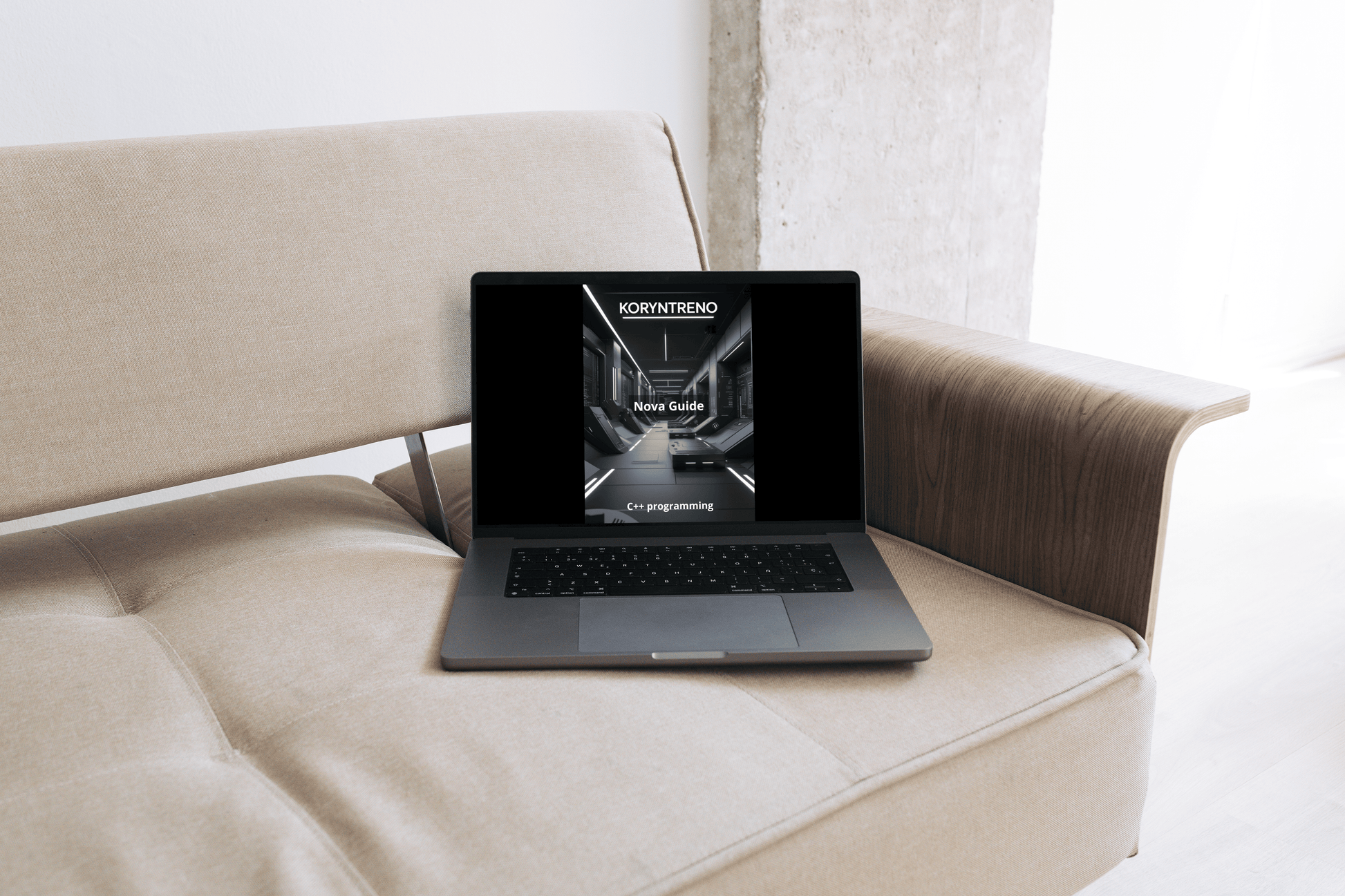 Laptop on a beige sofa with a C++ course.